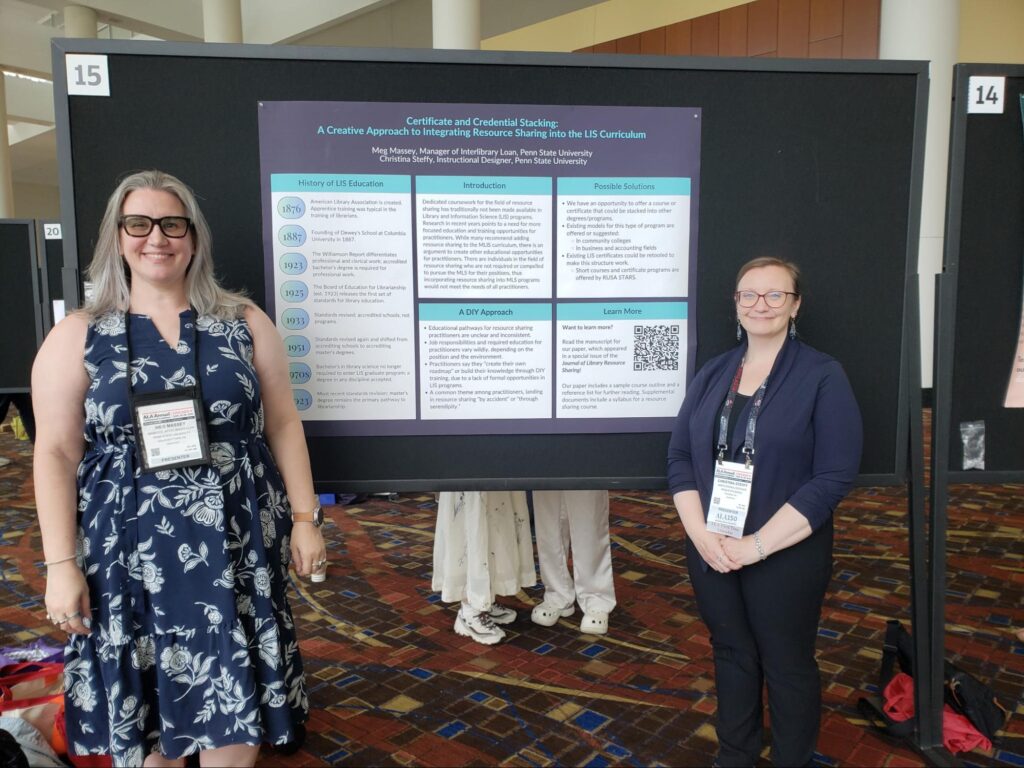Two women wearing conference badges stand in front of a poster pinned to a black board.